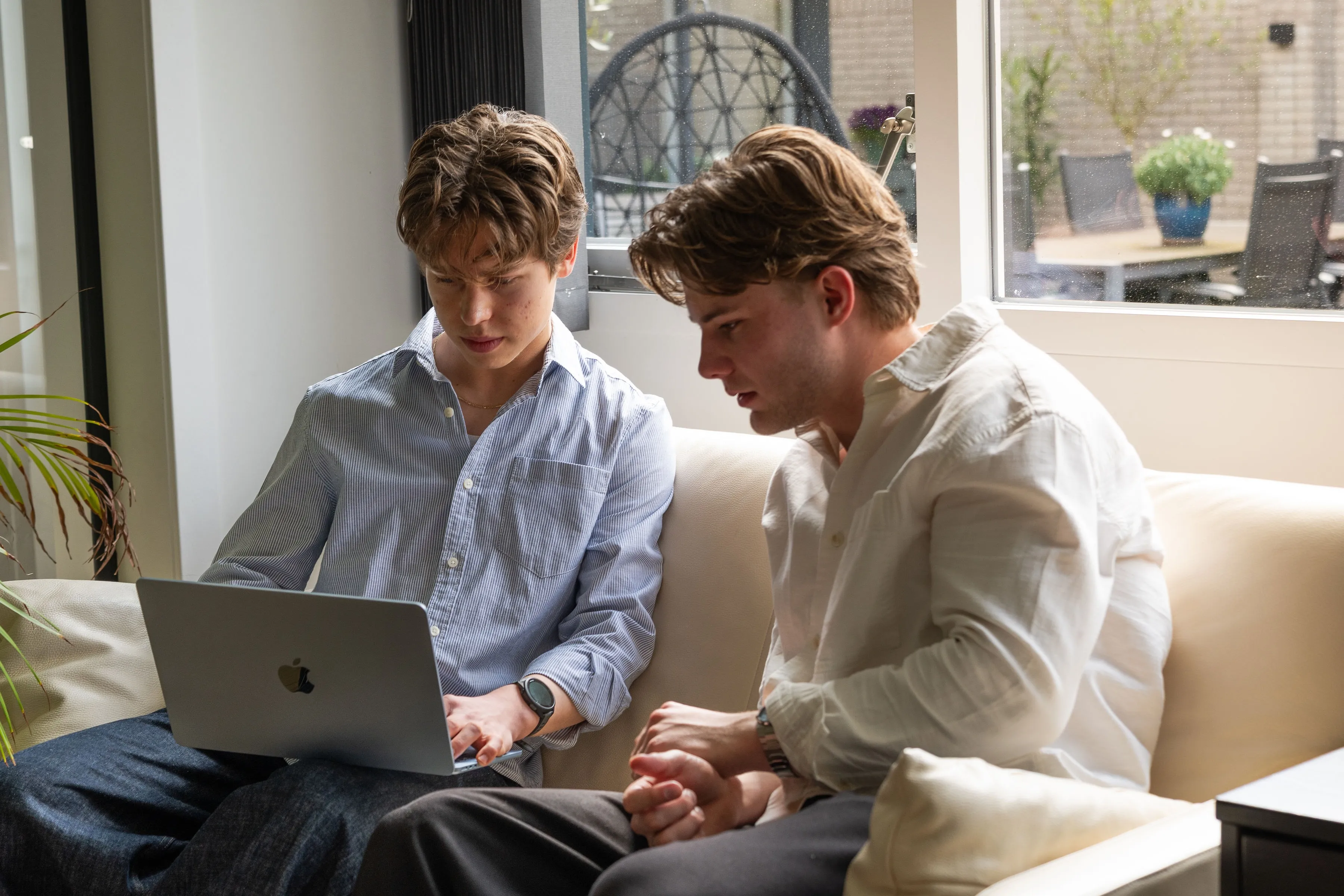 Thom en Pieter van Fidius Websites werken samen aan een website op een laptop